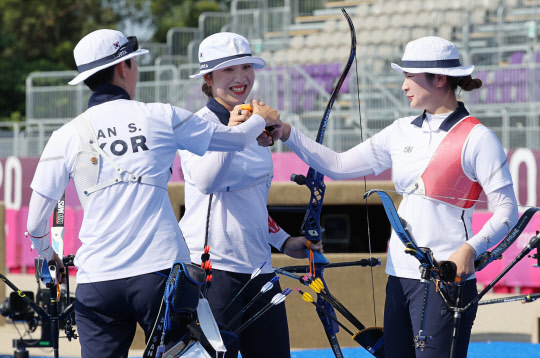 여자 양궁 국가대표가 25일 일본 유메노시마 공원 양궁장에서 열린 도쿄올림픽 여자 양궁 단체 4강전 벨라루스와의 경기에서 하이파이브를 하고 있다. <도쿄=연합뉴스>